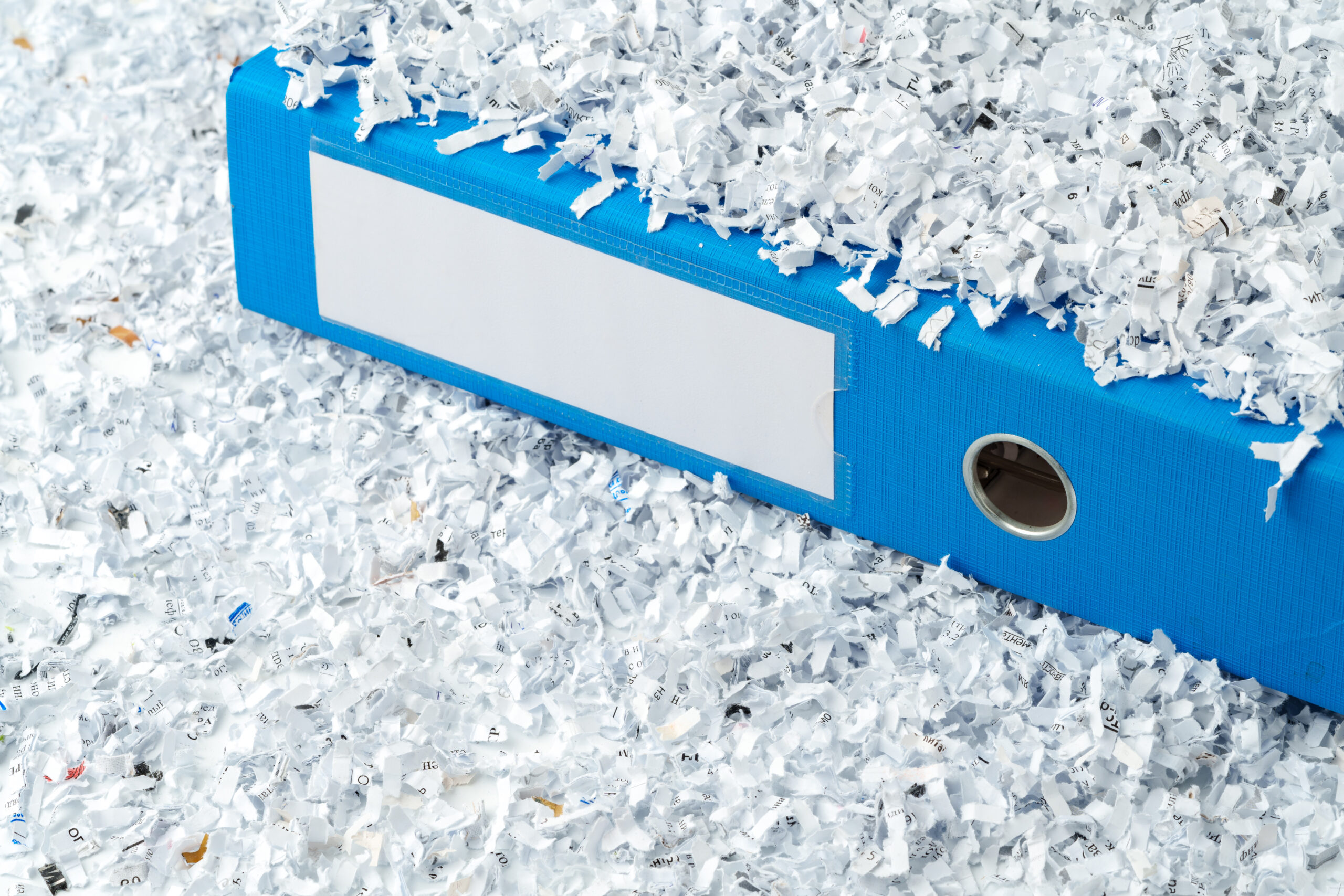 Paper folder and shredded paper in office close up