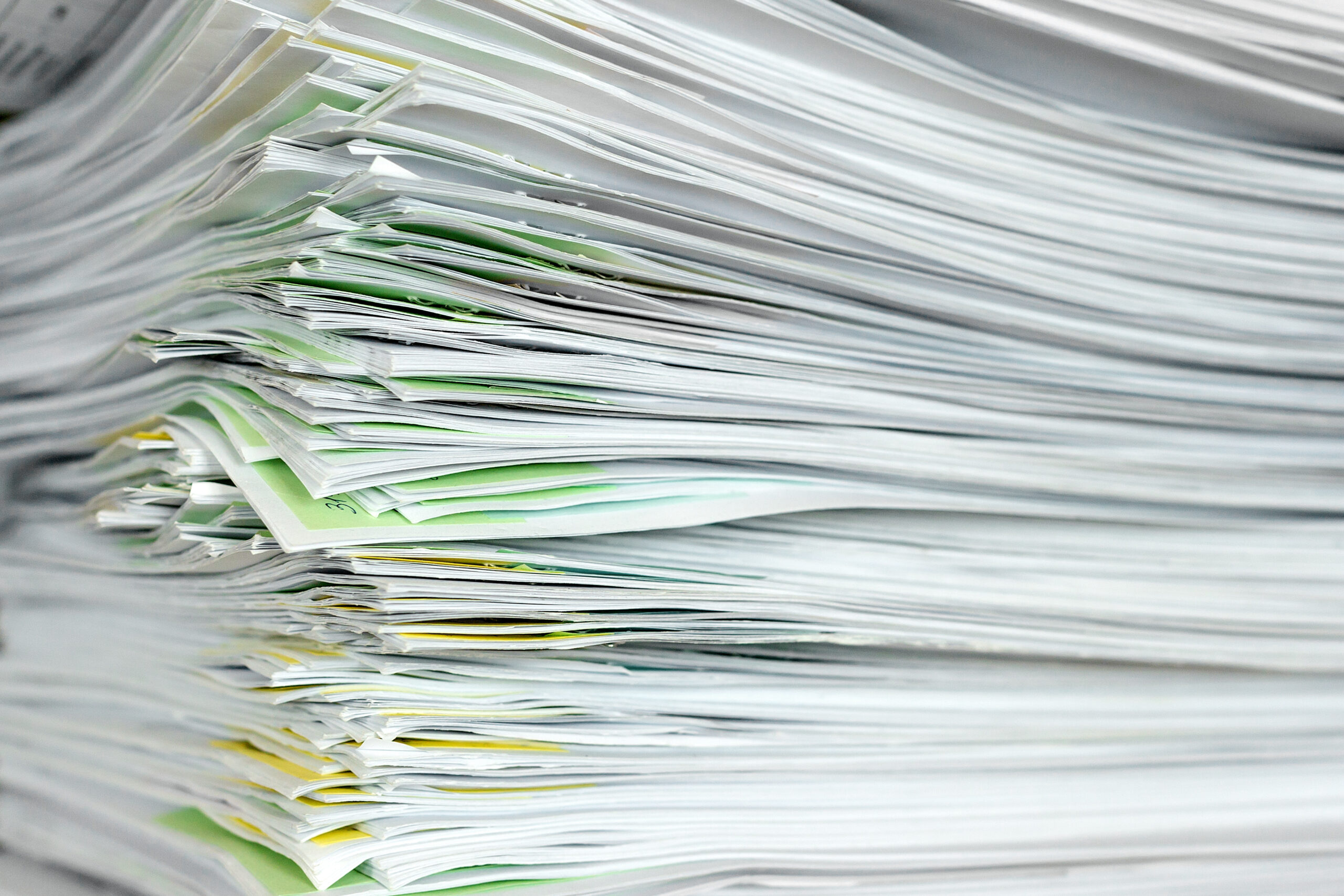 A stack of office papers on a table. Close up view. Selective focus.