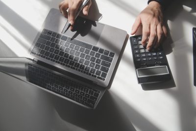 businessman working on desk office with using a calculator to calculate the numbers, finance accounting concept