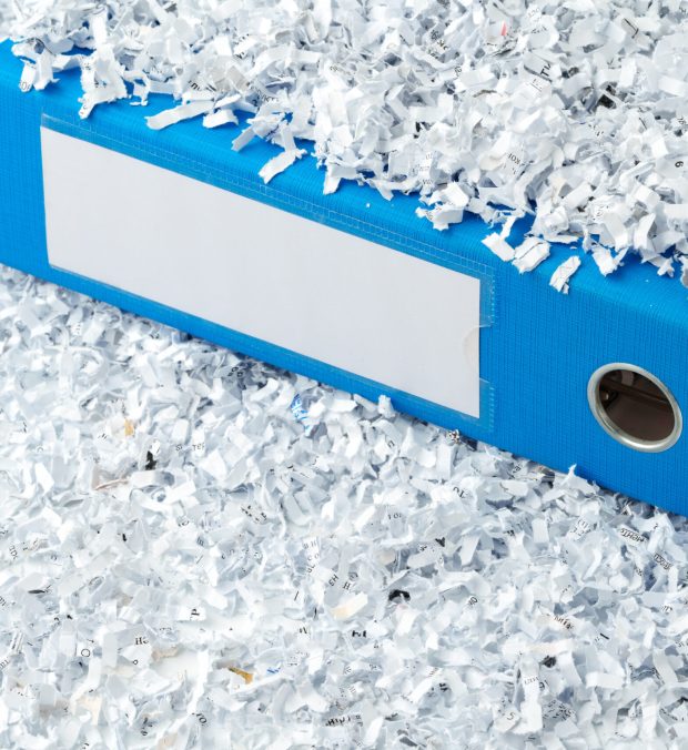 Paper folder and shredded paper in office close up